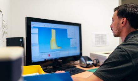 A designer modelling a 3D part on a computer